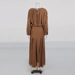 Detailed back view of an elegant brown pleated maxi dress with long sleeves and crew neck