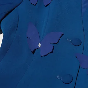 Gros plan sur une applique papillon 3D avec perles sur un blazer de luxe bleu élégant