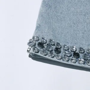 Dettaglio ravvicinato di decorazioni in strass sull'orlo di un vestito in denim azzurro