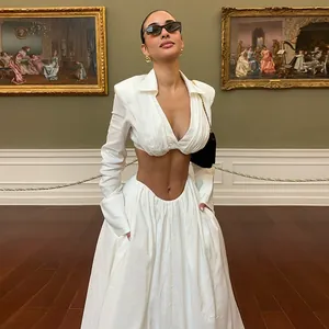 Model wearing an elegant white V-neck long sleeve crop top and matching maxi skirt set