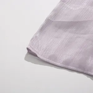 Macro detail of lavender pleated fabric showing fine stitching on a party dress
