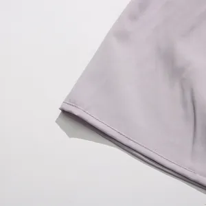 Detailed close-up of the hemline stitching on a lavender purple party dress fabric