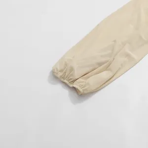 Close-up detail of beige elasticated pleated cuffs on a minimalist long sleeve dress