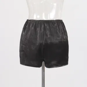 Detailed back view showing the metallic shiny fabric and elastic waist of black shorts