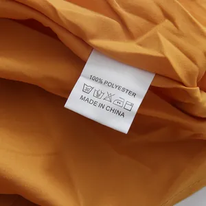 Vue détaillée de l'étiquette d'entretien 100 % polyester sur une robe d'été jaune