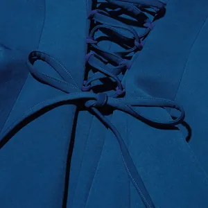 Gros plan d'une veste de luxe bleu foncé avec laçage au dos et détails de nœud papillon.