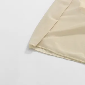 Close-up of beige lightweight fabric detail showing fine stitching and mesh texture