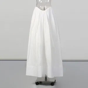 Front view of a minimalist long white gathered maxi skirt on a clear mannequin
