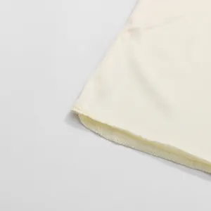Close-up detail of the fine stitching and hem on a minimalist cream white dress.