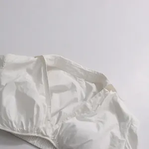 Detail view of elegant white V-neck cropped top with soft cotton fabric texture