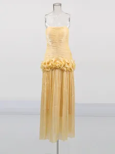 Elegant strapless pleated maxi dress with waist ruffle detail in champagne yellow