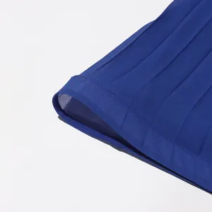 Gros plan sur un tissu plissé en mousseline bleue montrant sa texture délicate.