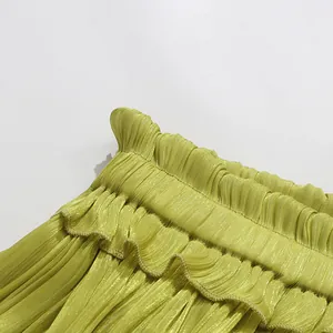 Close-up of lime green pleated fabric with ruffles and elasticated waistband detail.