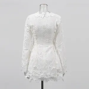 Vista detallada de la parte trasera del vestido de encaje blanco con flores caladas
