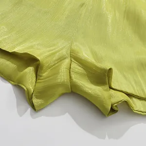 Macro view of lime green shimmery fabric showing pleated texture and glossy finish