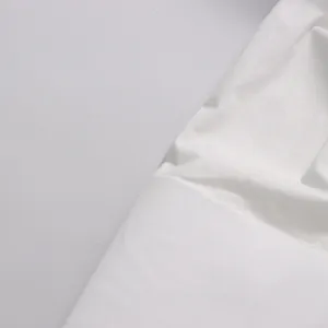 Close-up detail of the white fabric and stitching on the minimalist long sleeve top