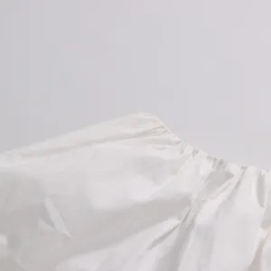 Detail shot of the soft elastic pleated waistband on a white cotton top or skirt