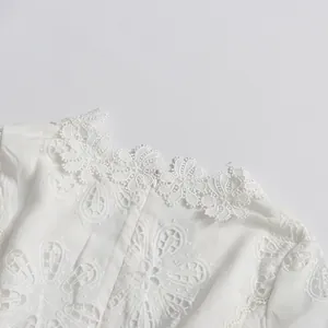 Primer plano de un vestido de encaje vintage blanco con bordados calados y cremallera
