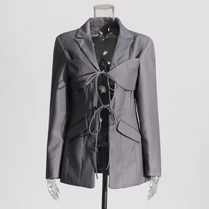 Vista frontale del blazer grigio stringato con design traforato sexy e cuciture irregolari.