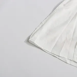 Detalle de la textura de la tela y las costuras finas del vestido blanco de estilo vintage