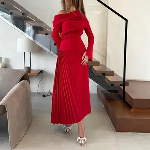Detalle de un elegante vestido rojo asimétrico plisado para mujer estilo celebridad