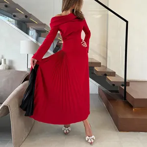 Detalle de vestido asimétrico rojo con pliegues elegantes y abertura lateral negra