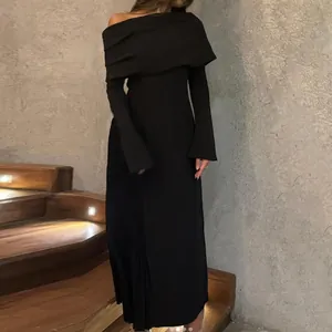 Elegante vestido largo negro asimétrico con hombros descubiertos y detalles de pliegues laterales