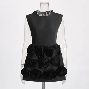 Detailed view of black mini dress with 3D fabric rose embellishments on the skirt