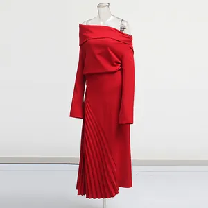 Detalle de vestido midi rojo con hombros descubiertos y abertura de pliegues asimétricos.