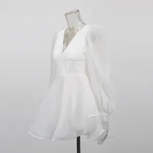 Side view detail of white V-neck mesh dress with corset waist and puff sleeves
