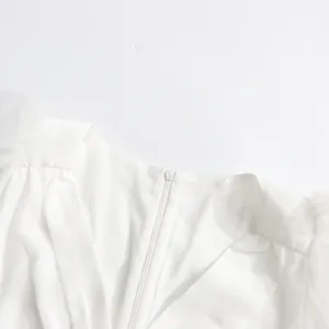 Macro detail view of invisible zipper and delicate pleats on a white mesh dress