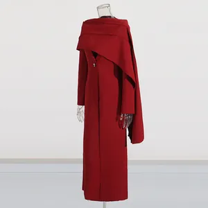 Detail view of a long dark red coat featuring an elegant integrated shawl design.