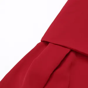 Vista detallada de la tela y los pliegues asimétricos de un vestido rojo