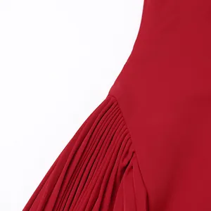 Primer plano de los elegantes pliegues y la abertura lateral de este vestido rojo