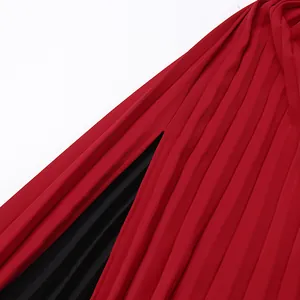 Detalle de un elegante vestido de noche rojo plisado con abertura alta y forro negro