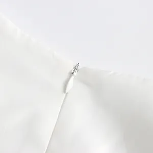 Close-up of the smooth invisible zipper detail on this elegant white mesh dress.