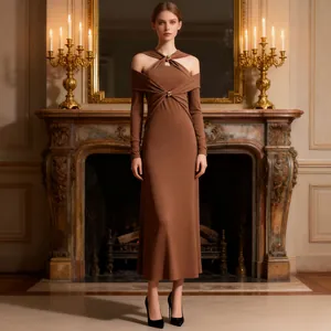 Elegante abito lungo in maglia marrone con scollo traforato in un ambiente di lusso.