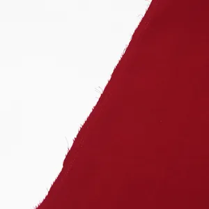 Close-up of deep red coat fabric texture showing high-quality stitching and raw edge