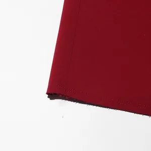 Close-up of wine red coat hemline showing double-needle stitching and fabric texture.