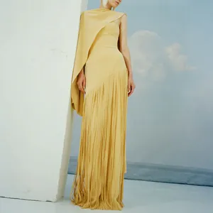 Detailed view of elegant pale yellow evening gown featuring a shawl design and long fringe skirt