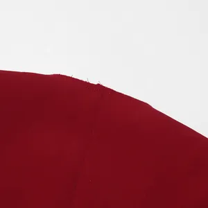 Close-up detail of the seam and wine red fabric on a high-end trench coat.