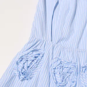 Close-up detail of a blue and white striped dress featuring unique 3D floral fabric decorations