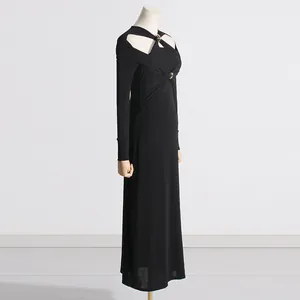 Vista dettagliata di un abito lungo in maglia nera con eleganti tagli sulle spalle