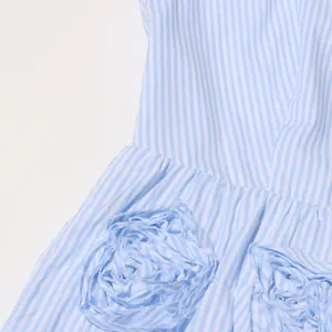 Close-up of 3D fabric flower detail on blue and white striped French vintage dress