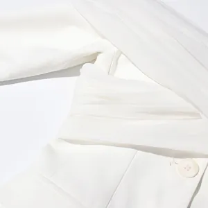 Detalle de chaqueta blanca con elegante panel de malla y diseño de hombros descubiertos