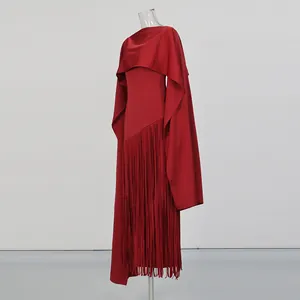 Elegant red long dress detail featuring a stylish cape overlay and long fringe hemline