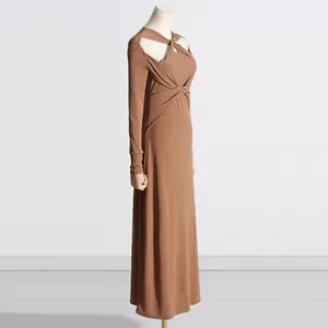 Dettaglio laterale di un abito lungo in maglia marrone slim con design cut-out.