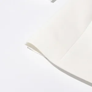 Primer plano del tejido de blazer blanco con textura fina y costuras profesionales.