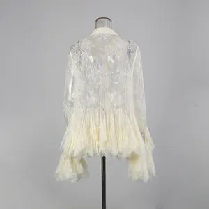 Rückansicht eines eleganten weißen Spitzenkleids mit ausgestellten Ärmeln und Rüschen.