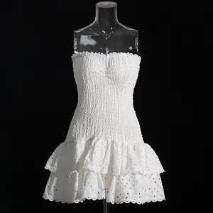 Close-up detail of white strapless eyelet lace mini dress featuring smocked bodice design
